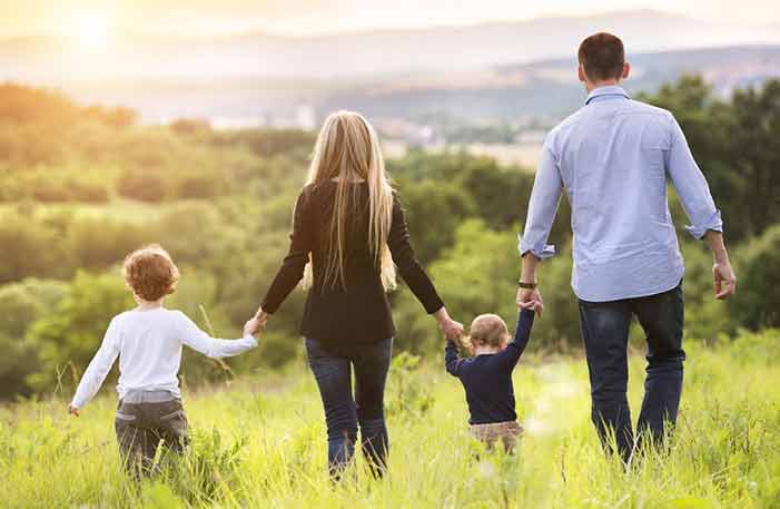 Family walking in green field