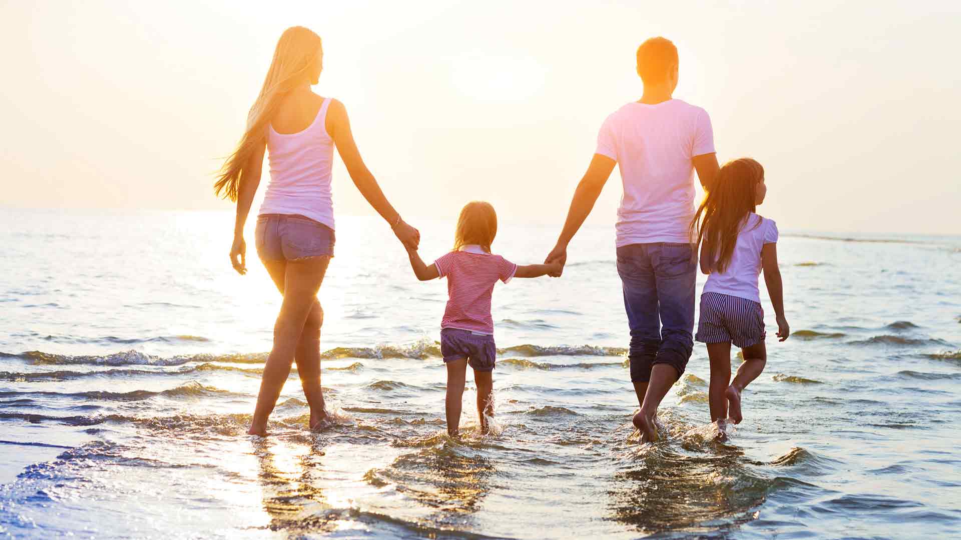 Family walking on the beach during sunset