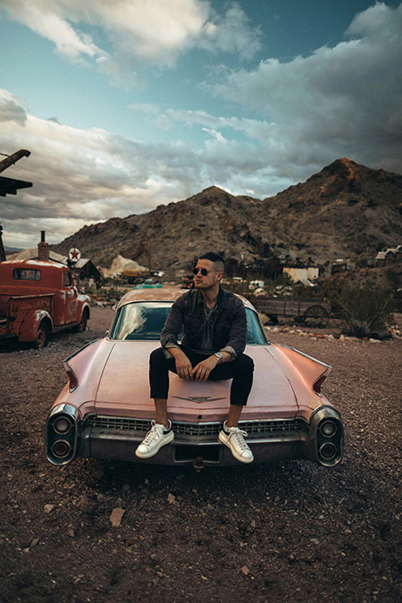 Vintage Car owner sitting on his car